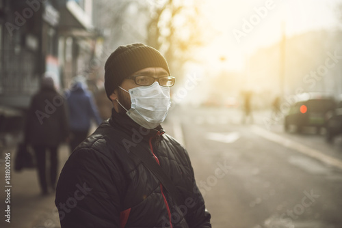 Plakat A man wearing a mask on the street. Protection against virus and grip