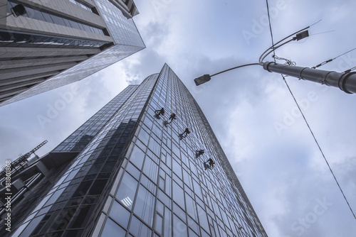 Window washers cleaning the glass facade of a skyscraper photo