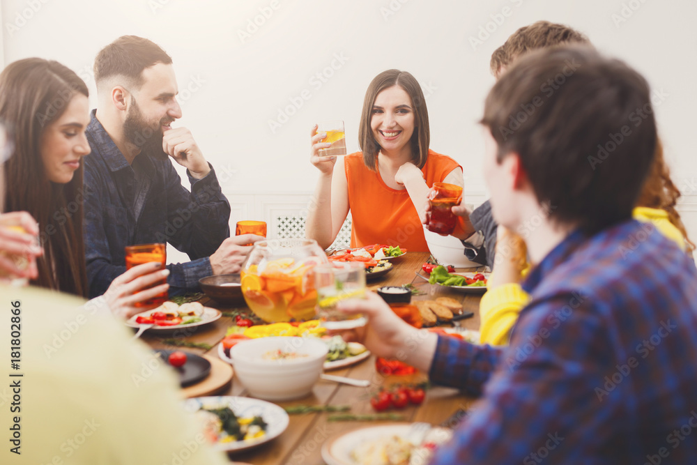 Group of happy young people at festive table dinner party