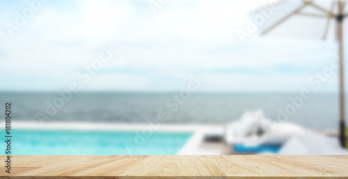 toble top of wood and Luxury swimming pool and blue water at the resort with beautiful sea viewbackground. photo