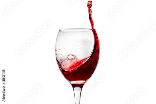 Wineglass with splashing drops of red wine