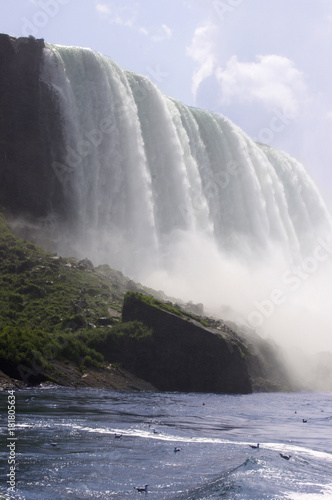 Large waterfall on rock cliff with mist