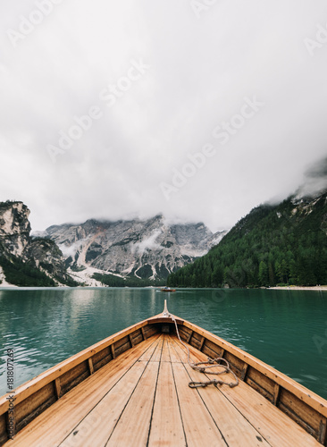 Boats on Lago di Braies mountain lake during rainy day