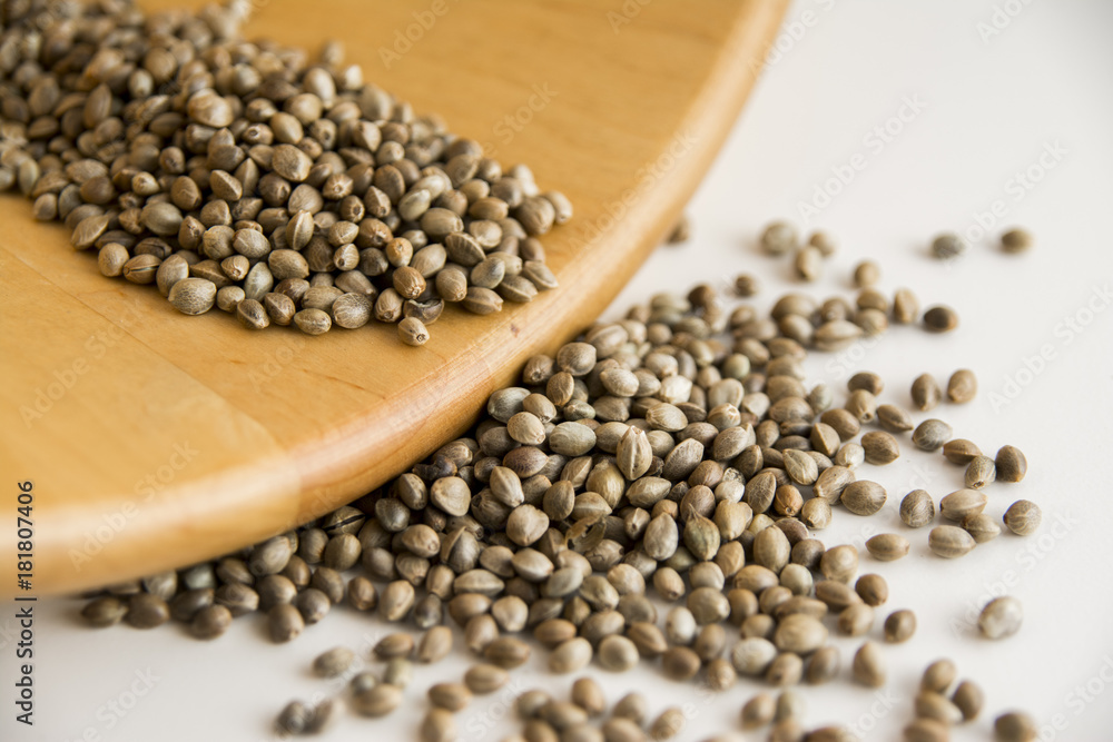 Edible raw hemp seeds on wooden spoon. Close up of hempseed cannabis plant seeds. Edible raw hemp seeds on wooden spoon. Close up of hempseed cannabis plant seeds.