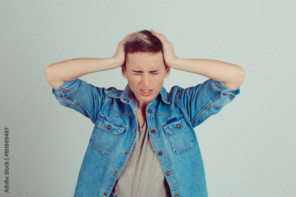 Stressed Pretty brunette getting a headache with hands on head on green grey white background Stressed Pretty brunette getting a headache with hands on head on green grey white background