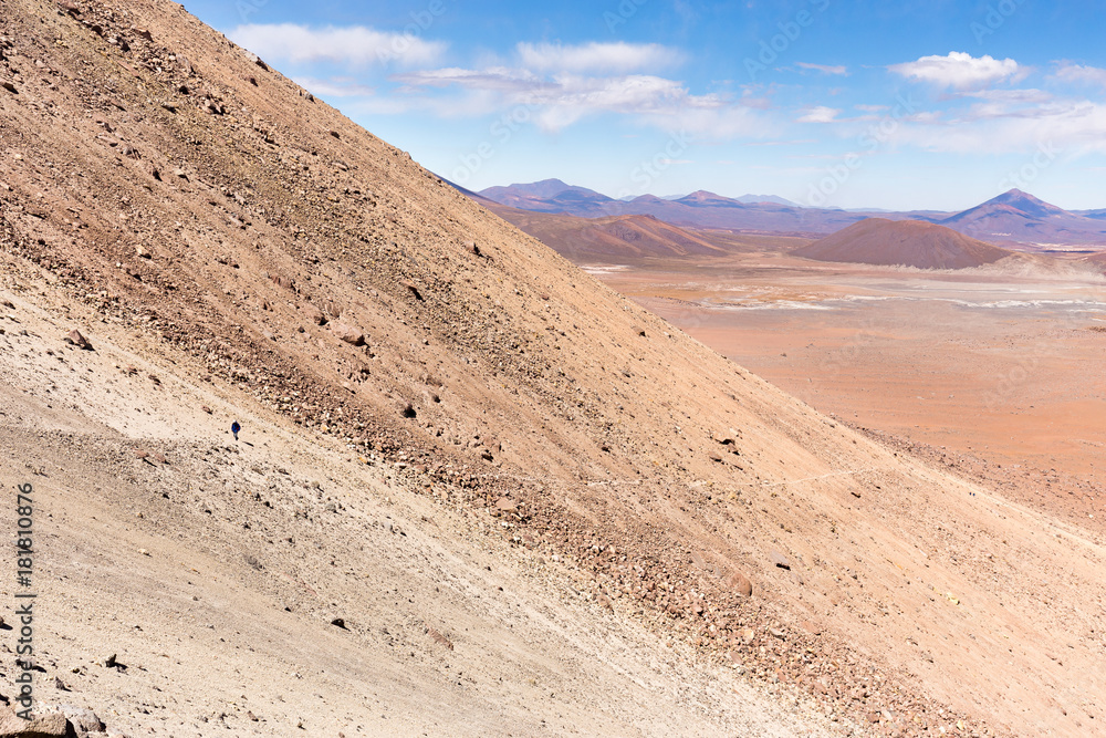 Man walking volcano mountain trail Salar De Uyuni, Bolivia