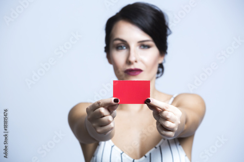 bella ragazza mora ci mostra una card rossa - sfondo celeste chiaro