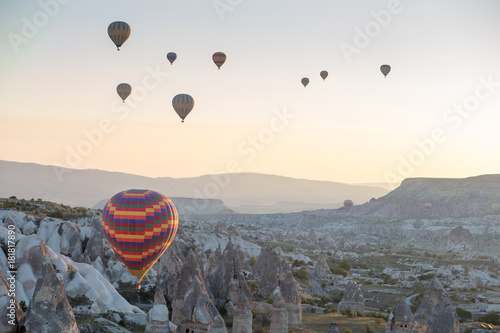 Hot air balloons over mountain landscape in Cappadocia, Goreme National Park, Turkey.