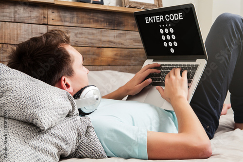 Man entering code in a laptop to get access to a private system while rest at home.
