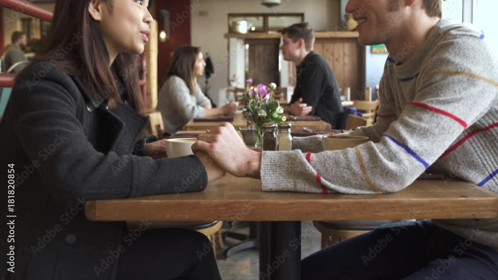 Push-in shot of a couple holding hands in a restaurant Push-in shot of a couple holding hands in a restaurant
