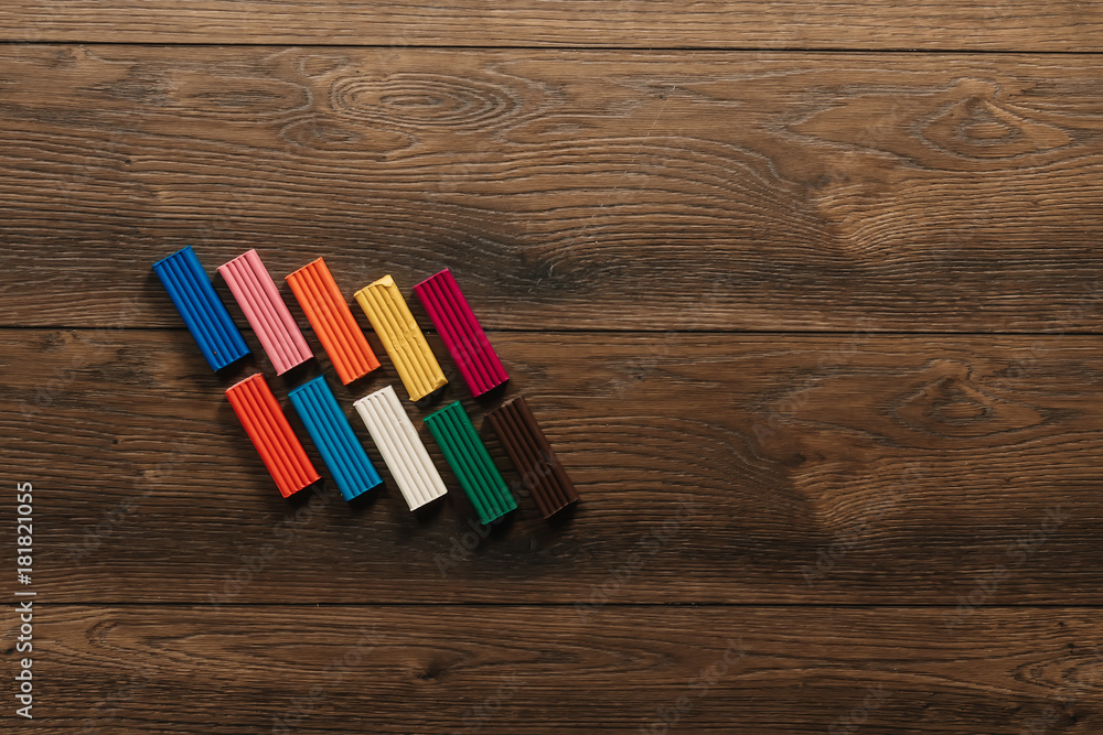 Obraz premium Colored clay lies on a wooden brown table. Copy space.