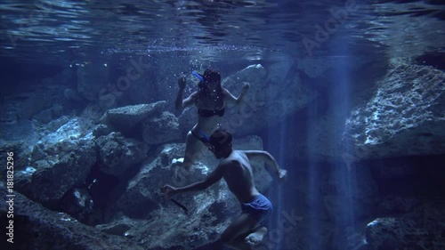 couple in swimsuit make a himself photo underwater in cenote cave dos ojos