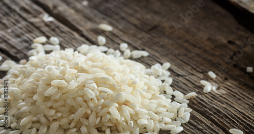 Heap of raw rice on an old wooden surface