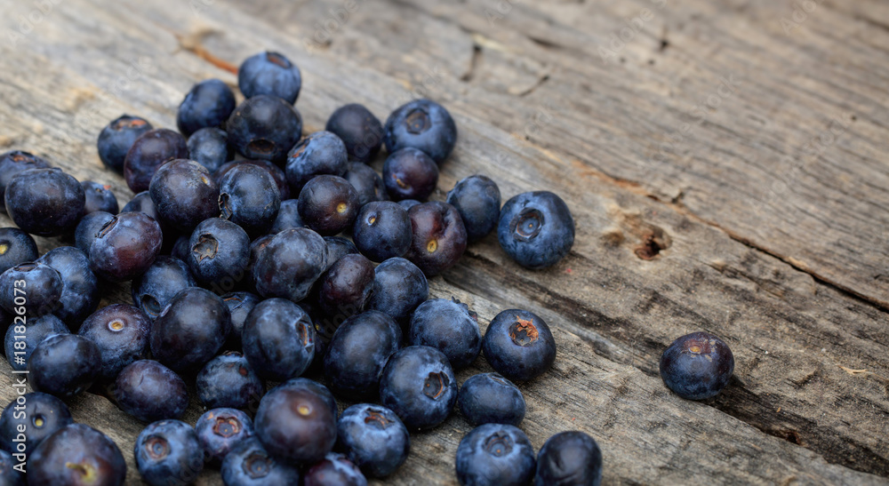 Fototapeta premium Stack of blueberries, on a wooden surface, copy space