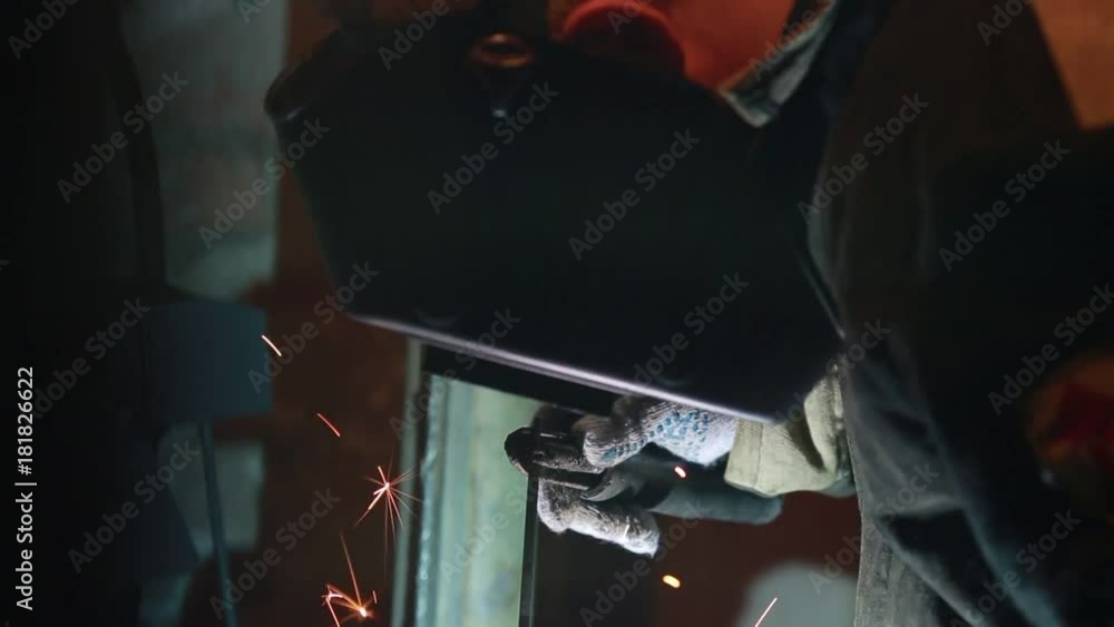 The welder works with welding. Builder welds parts outdoors. Installation of piping under ground in the winter day. Man work in gloves and protective clothing in the pit. Dangerous manual labor outsid The welder works with welding. Builder welds parts outdoors. Installation of piping under ground in the winter day. Man work in gloves and protective clothing in the pit. Dangerous manual labor outsid