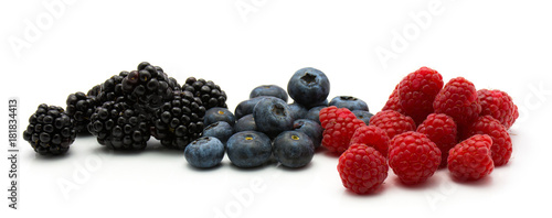 Berries isolated on white background three separated heaps of blackberry blueberry and raspberry.