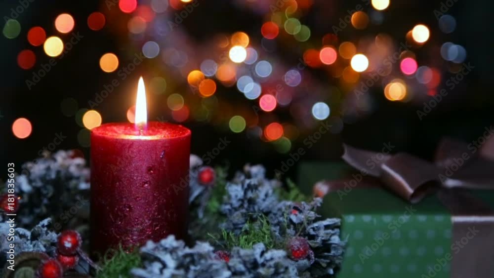 A lighted candle and a gift box on the background of a bokeh A lighted candle and a gift box on the background of a bokeh