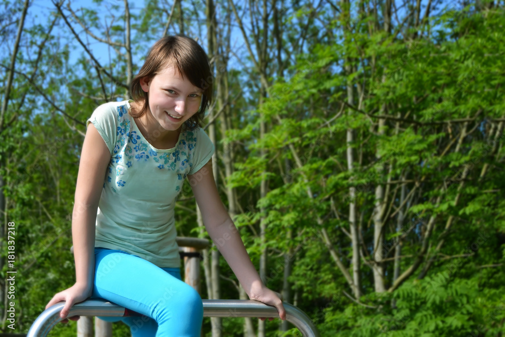 Happy teenage girl smiling sitting on a metal pipe in the park Happy teenage girl smiling sitting on a metal pipe in the park