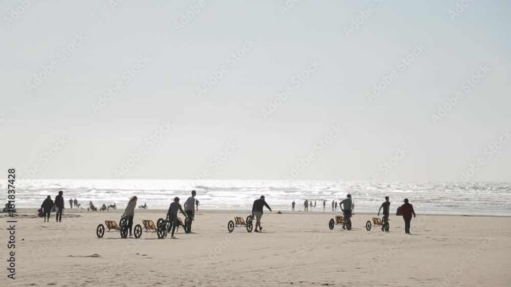 People are driving a three-wheeled bicycle along the beach in the background People are driving a three-wheeled bicycle along the beach in the background