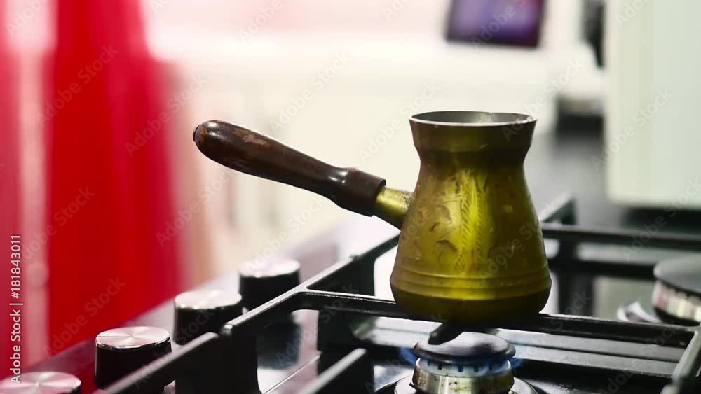 Making turkish coffee in copper cezve over gas stove. Milling of grains