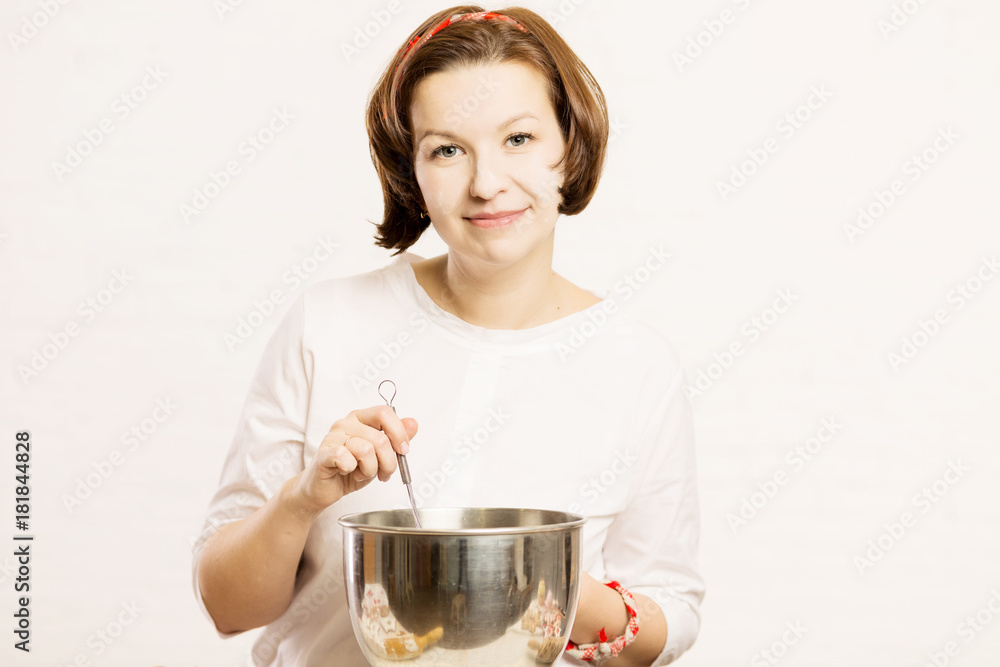 A young confectioner kneads the dough in a bowl from a mixer A young confectioner kneads the dough in a bowl from a mixer