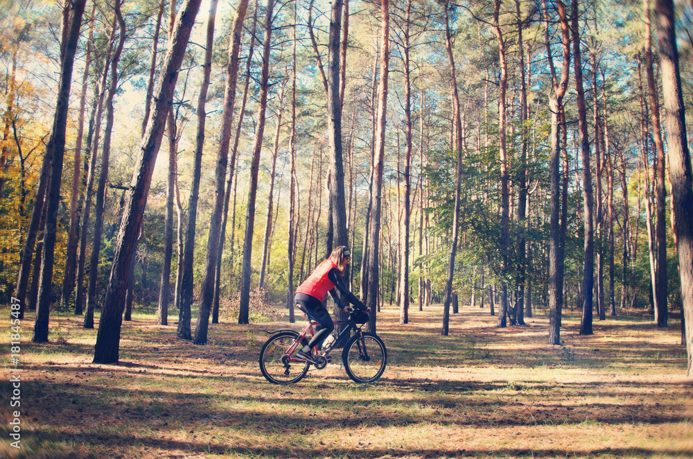 the girl is riding a bicycle through the woods