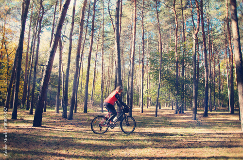 the girl is riding a bicycle through the woods