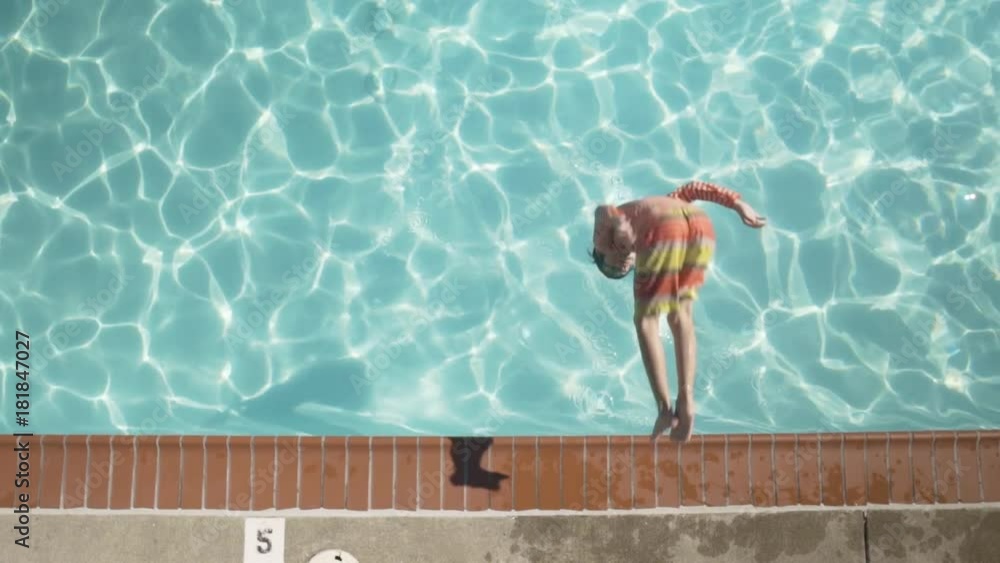 High-angle shot of a boy jumping into a pool