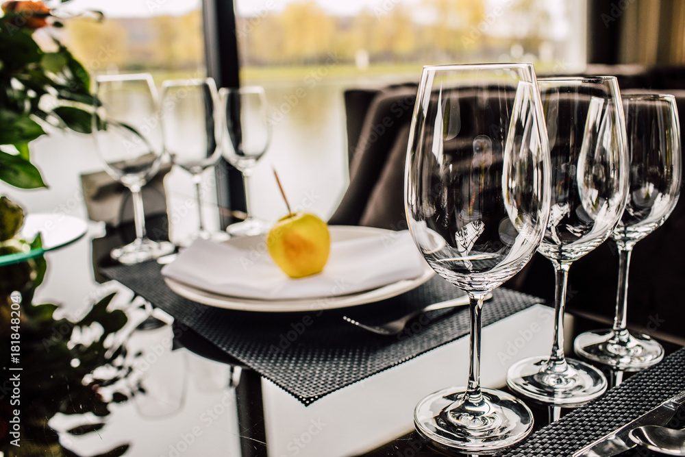 Sparkling glassware stands on long table prepared for wedding dinner