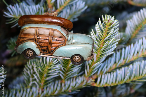 Fotografie Retro Christmas ornament - A woody car with a canoe on top hanging on silver spr