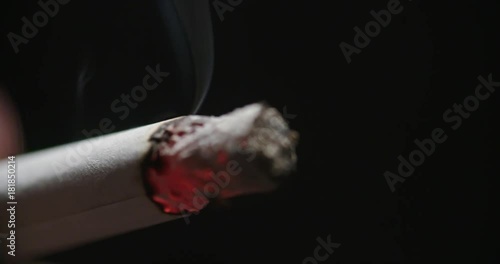 Close Up Cigarette End Burning on Inhale. a close up view of the end of a cigarette burning with the inhales