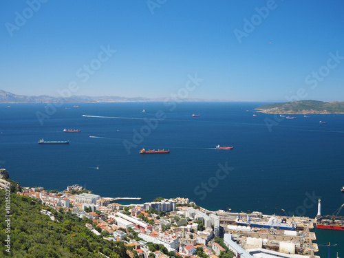 View from the Rock of Gibraltar of container and cargo ships passing through the Strait of Gibraltar with Morocco in the distance