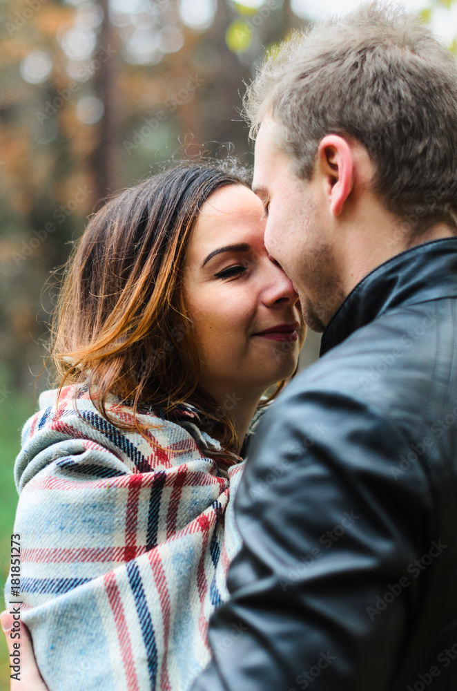 the guy with the girl walking in autumn Park. cool , snuggle under a blanket the guy with the girl walking in autumn Park. cool , snuggle under a blanket