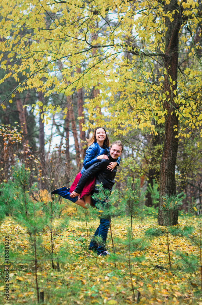 The guy with the girl walking in the Park , in a good mood. dressed in jackets, autumn time. The guy with the girl walking in the Park , in a good mood. dressed in jackets, autumn time.