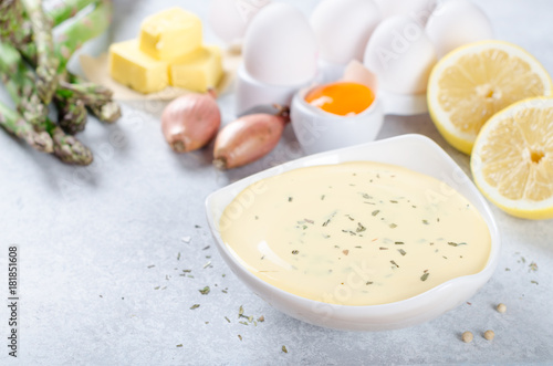 Basic french sauce bearnaise in a white bowl with ingredients, b