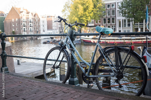 Bicycles and flowers in Amsterdam Holland Netherlands near famous UNESCO world heritage canals Singel with typical dutch houseboats