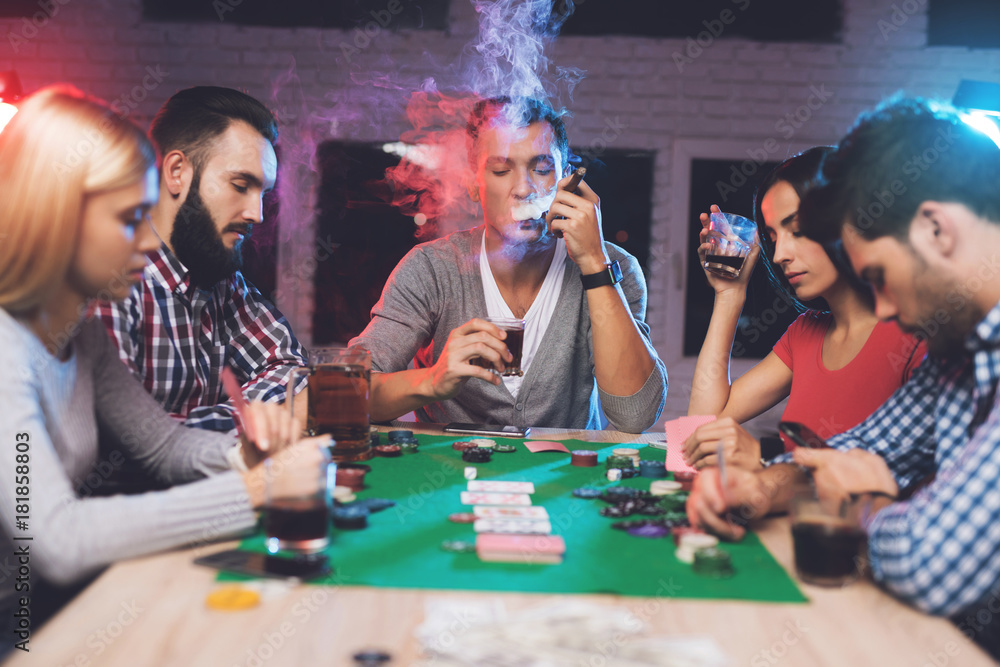 Young people play poker at the table. Young people play poker at the table.