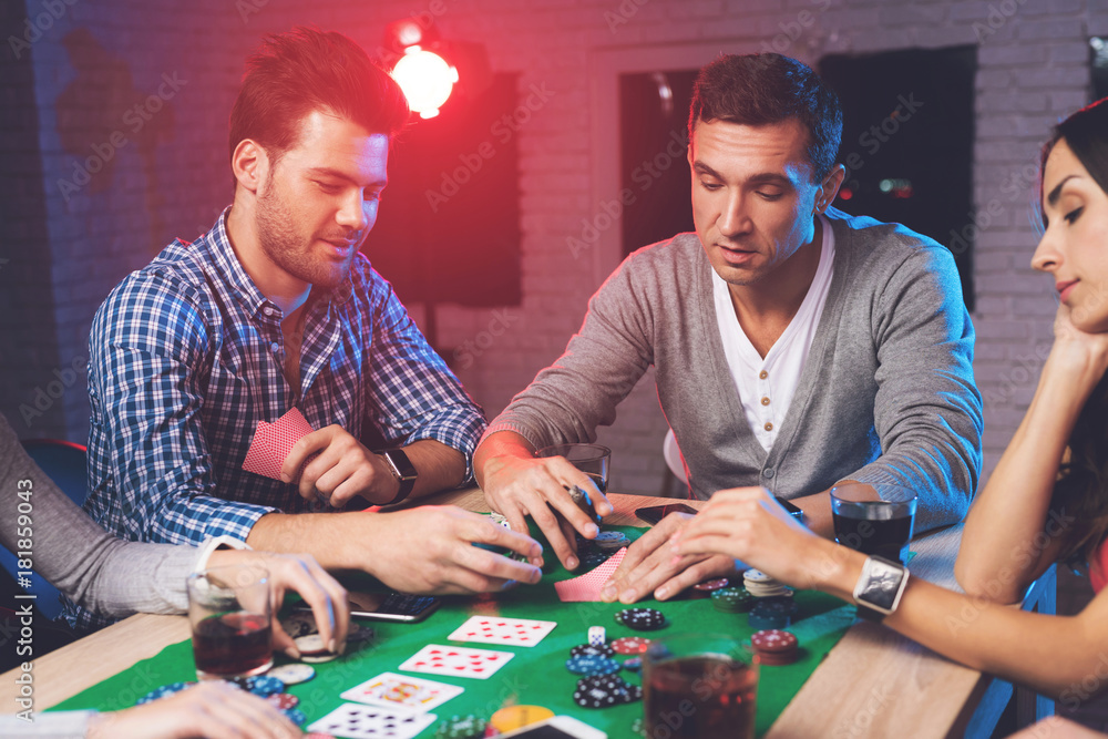 Young people play poker at the table. Young people play poker at the table.