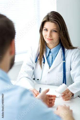 Doctor writes out the pills to the patient