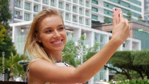 Wallpaper Mural Young beautiful slim woman with long blonde hair in black and white dress making selfie on mobile phone over background the park. Torontodigital.ca