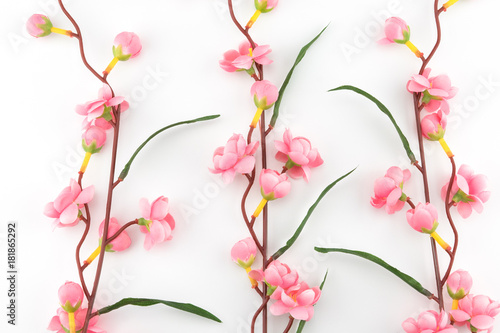 Fake pink flower branches on white background 