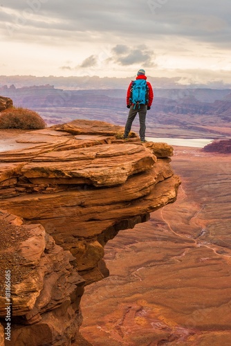 A hiker overlooking the valley and sunset in Canyonlands