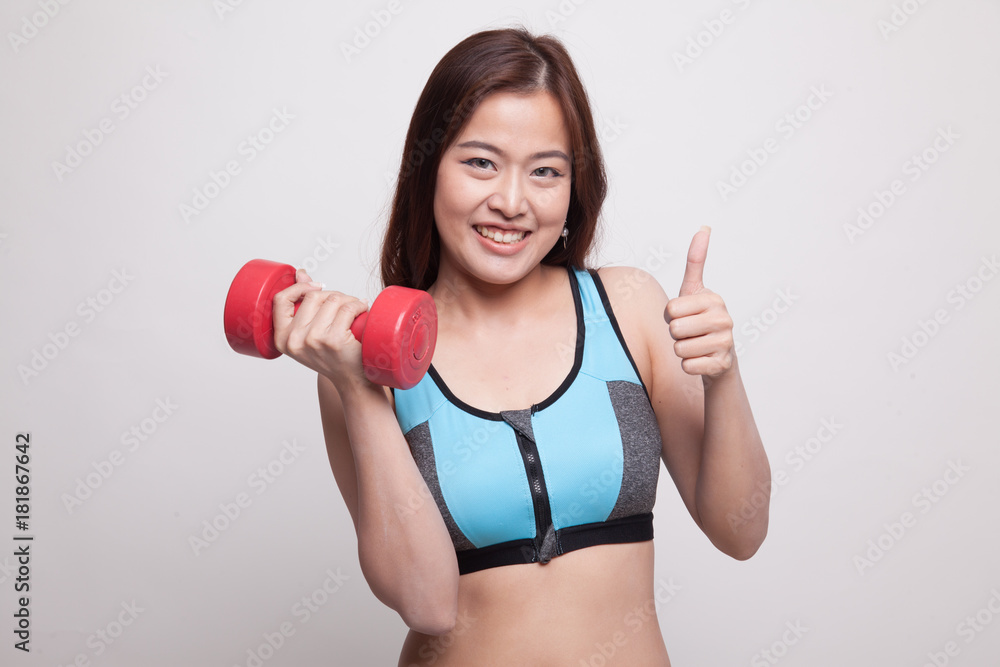 Beautiful Asian healthy girl thumbs up with dumbbell. Beautiful Asian healthy girl thumbs up with dumbbell.