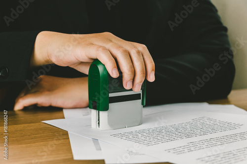 Close-up hand stamping of businesswoman for signing approval on documents , business concept