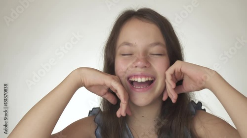 Beautiful happy teenage girl dreams, smiling and laughing close-up on white background stock footage video