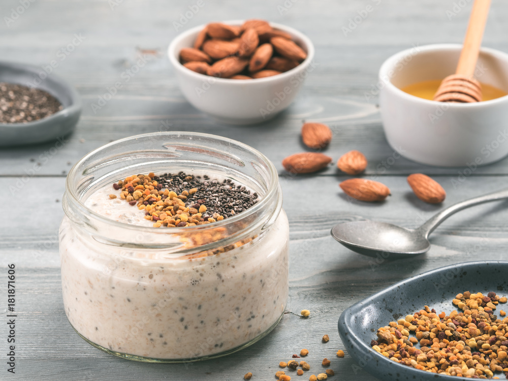 Overnight oats in jar and ingredients on gray wooden table Overnight oats in jar and ingredients on gray wooden table