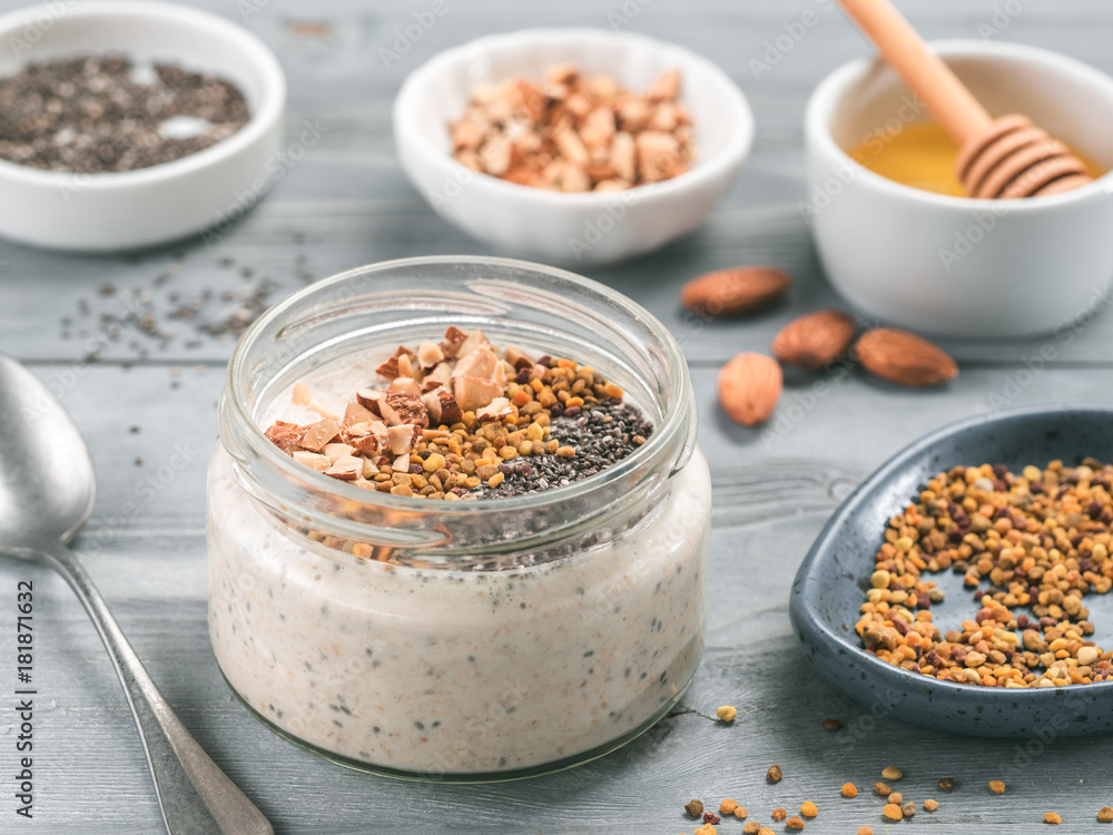 Overnight oats in jar and ingredients on gray wooden table Overnight oats in jar and ingredients on gray wooden table