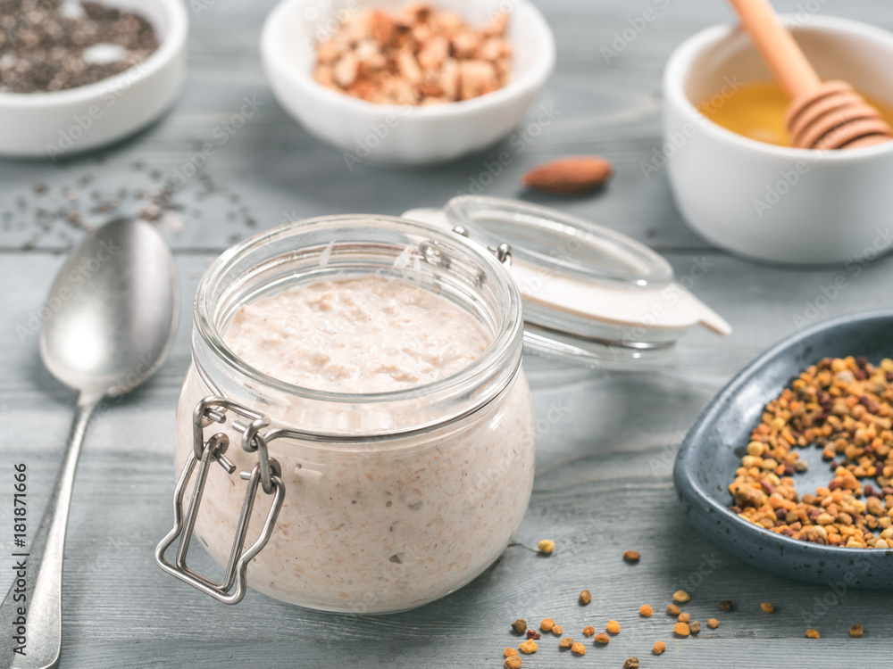 Overnight oats in jar and ingredients on gray wooden table Overnight oats in jar and ingredients on gray wooden table