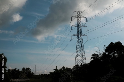 High voltage pole with blue sky and rainy cloud.