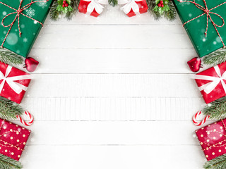 Christmas gift boxes with pine and decorating ornaments on white wood background